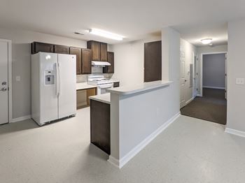 A kitchen with white appliances and brown cabinets.